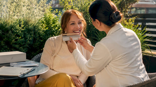 Patient consulting dentist with teeth shade guide