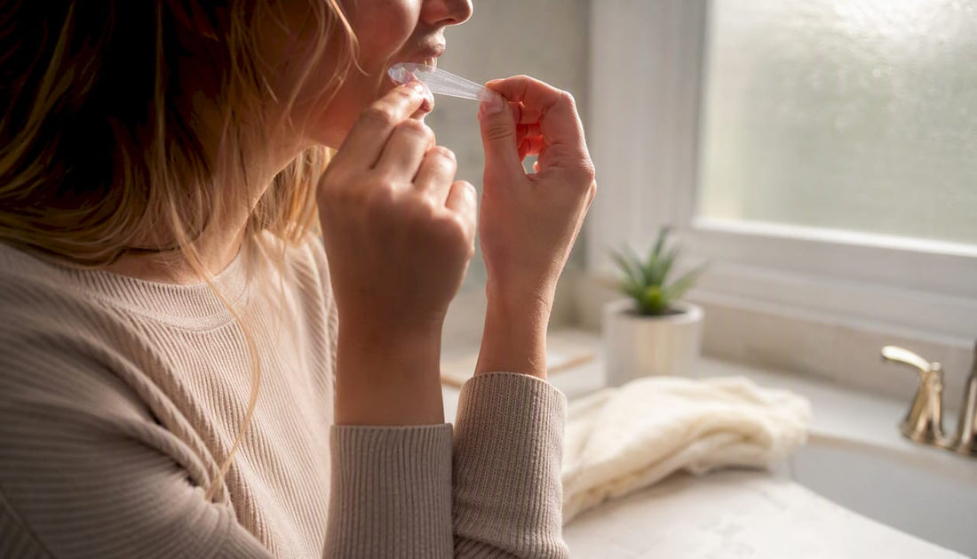 Hands removing whitening strips over a bowl of water