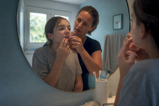 Parent helping teen apply teeth whitening strips