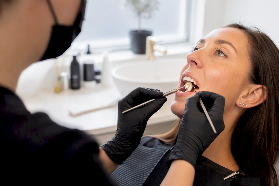 Dental tools inspecting brown tooth stain