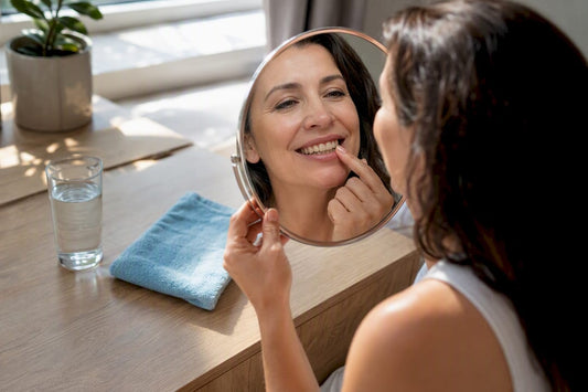 Woman examining nicotine-stained teeth in mirror